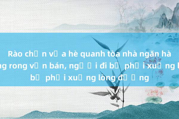 Rào chắn vỉa hè quanh tòa nhà ngăn hàng rong， hàng rong vẫn bán， người đi bộ phải xuống lòng đường